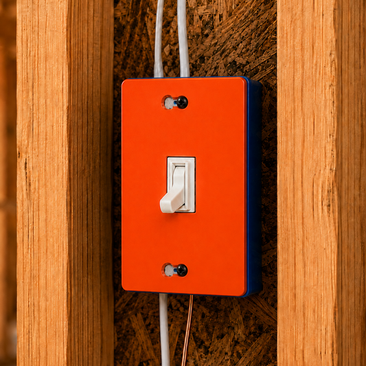 Orange light switch panel with white switch on a wooden wall.